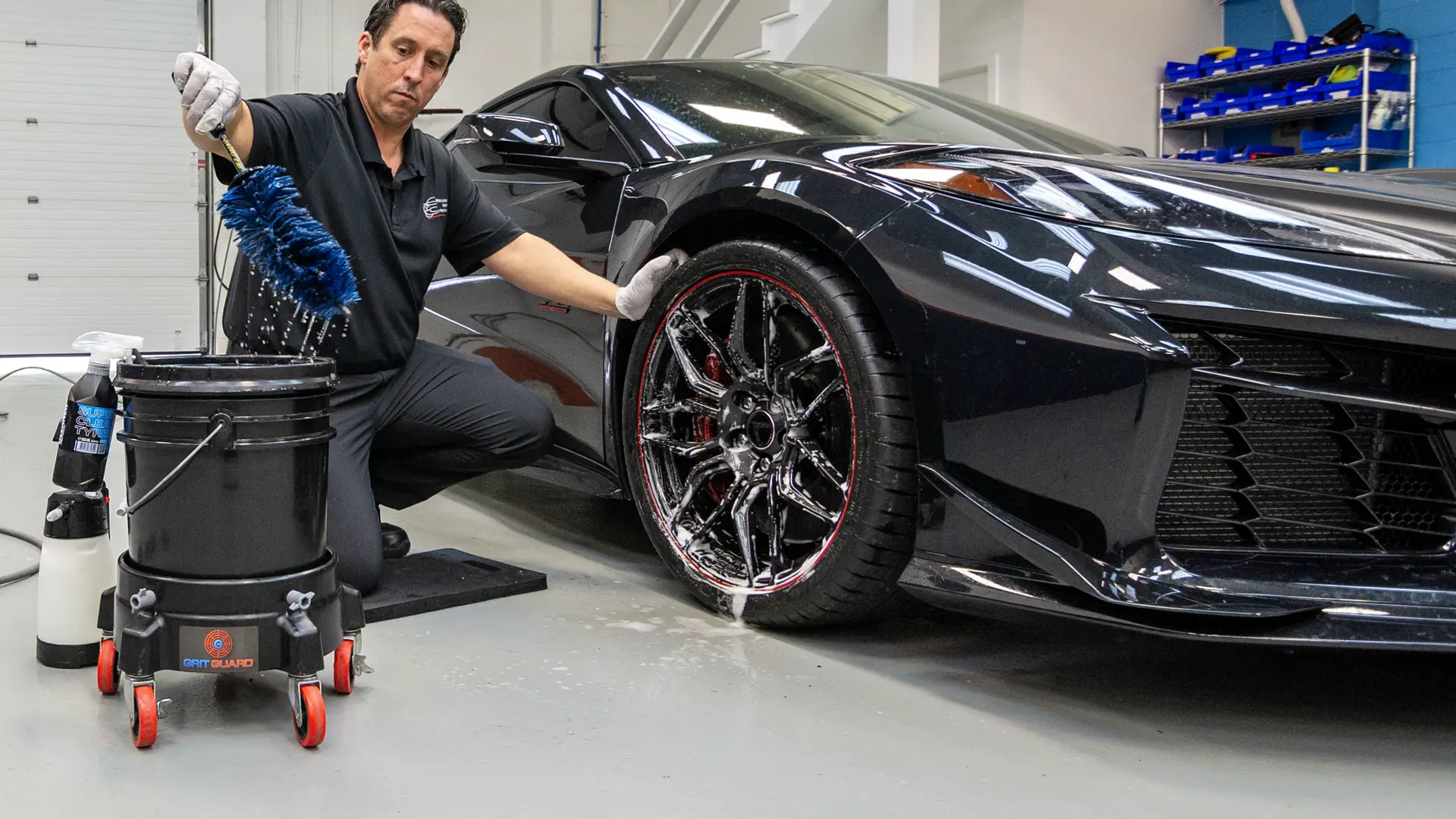 When learning how to hand wash a car properly, cleaning deep inside the wheels is a crucial step that is often skipped. Here, the best way to hand wash car wheel barrels is demonstrated on a 2023 Chevrolet Corvette Z06 in Carbon Flash Metallic, using a specialized barrel brush to remove heavy brake dust.